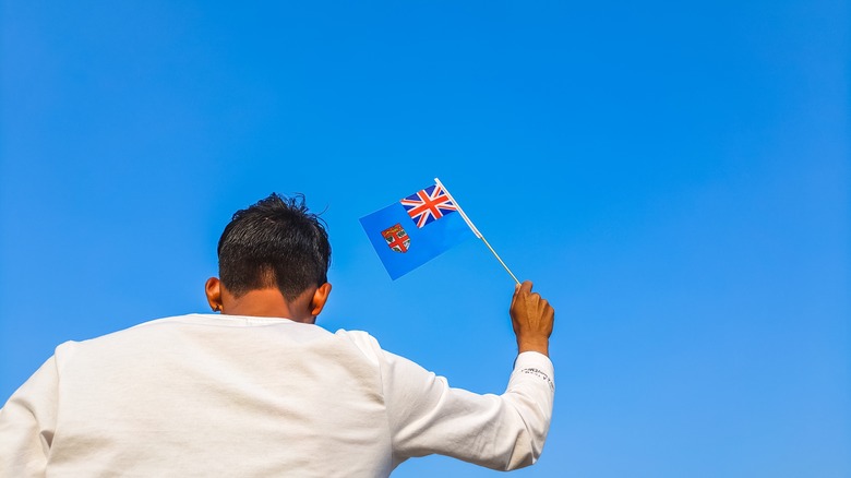 Patriotic man waves Fijian flag