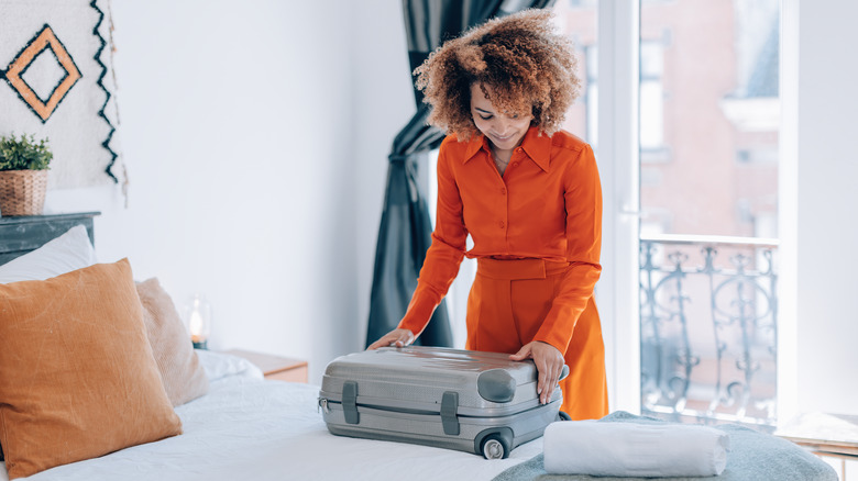 Woman unpacking in hotel room