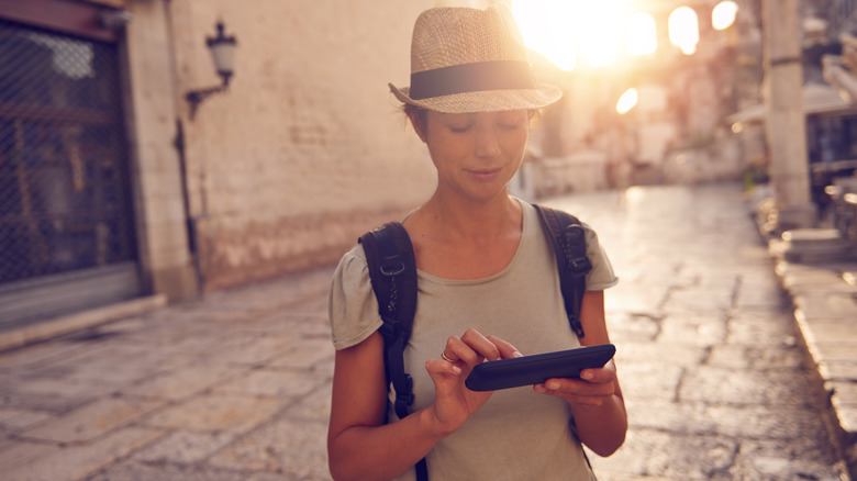 traveler phone on quiet street sunrise 