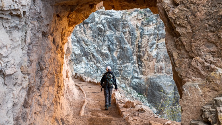 hiker in rock arch bright angel trail