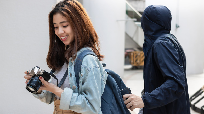 pickpocket takes wallet out of backpack