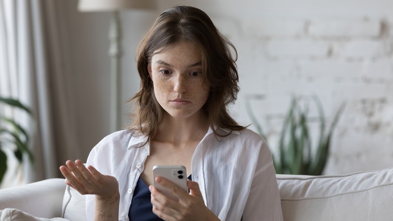 woman shocked and annoyed at cellphone