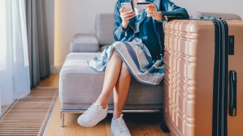 woman in hotel room paying online