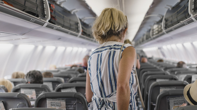 woman walking to back of plane