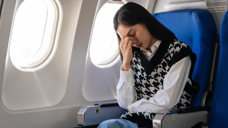 A woman feeling discomfort during a plane ride