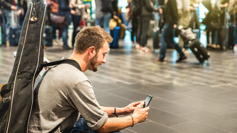 man with guitar in airport