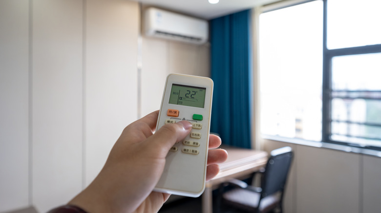 Person fixing the hotel thermostat