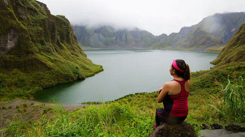 Woman sitting at Mount Pinatubo crater lake