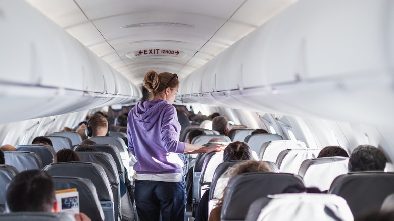 passenger walking airplane aisle