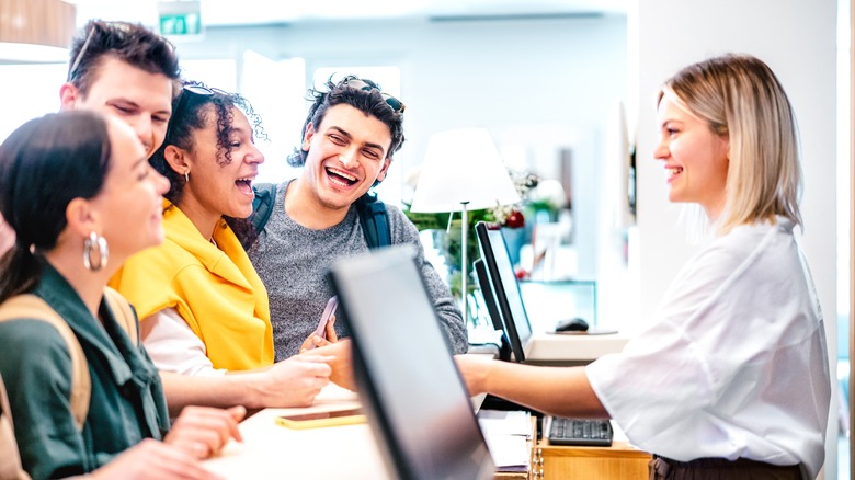 smiling guests and hotel employee