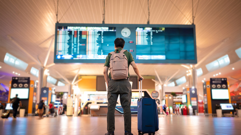 Man at airport departures board