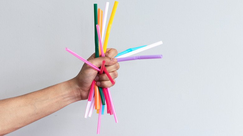 Fist holding colorful plastic straws