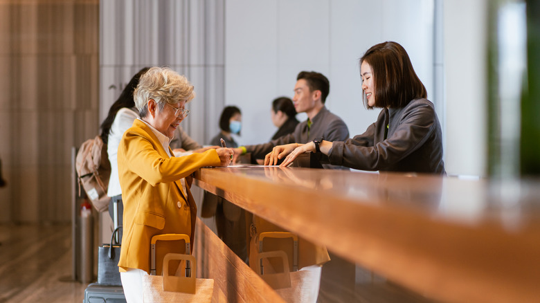 woman paying at hotel desk