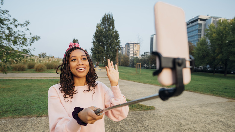 Woman taking selfie with stick