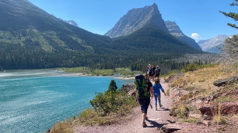 Hikers near a lake with mountains in background