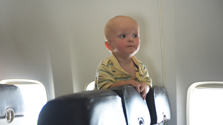 baby looking over airplane seats