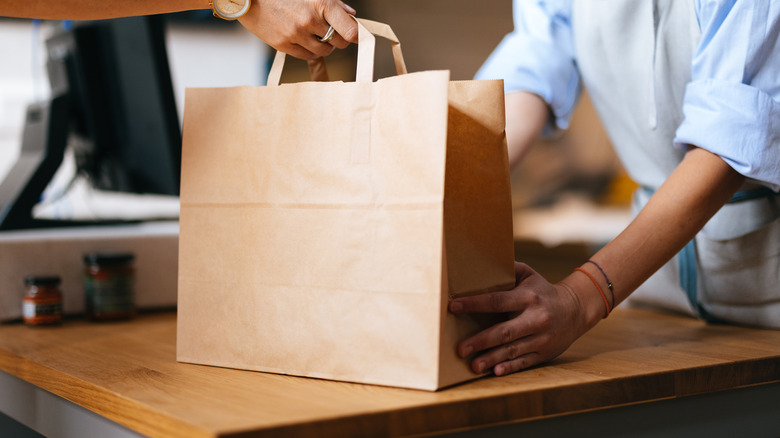 Person grabbing a grocery bag