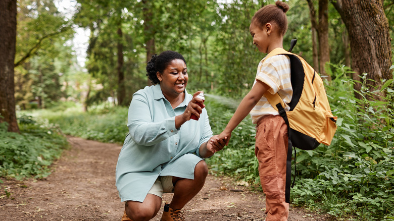 Mother sprays insect repellent