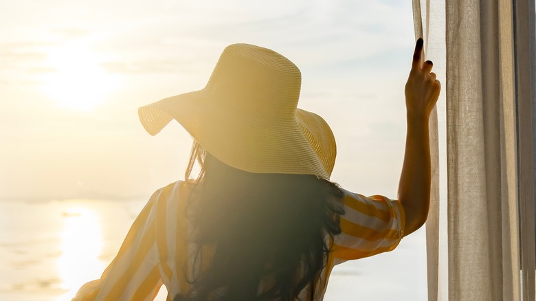 woman looking out window at ocean