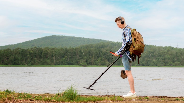 Man using metal detector at lake