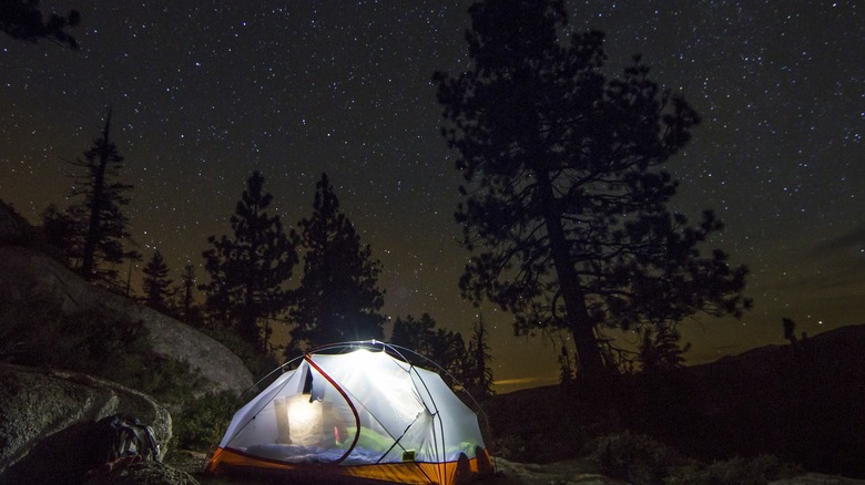 lit tent under starry sky