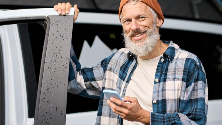 happy outdoorsy man using phone